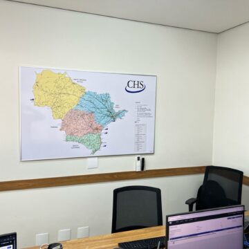 foto de um escritório comercial com um mapa emoldurado com moldura de alumínio contendo os estados do mato grosso do sul, são paulo, paraná e santa catarina, portos, ferrovias e rodovias